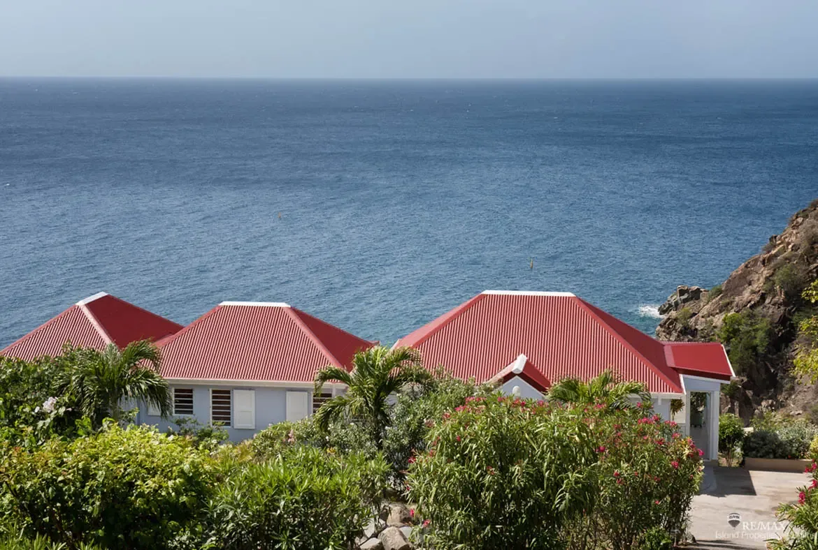 Tucked amid flowering tropical gardens and swaying palms, the villa's red roofs crown this hillside sanctuary. The endless Caribbean stretches to the horizon—your private postcard where every sunrise and sunset belongs only to you.