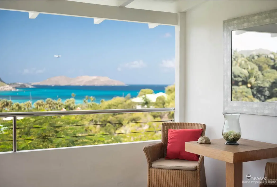 A peaceful balcony with sailboat views over the turquoise bay — settle in and watch island life drift by.