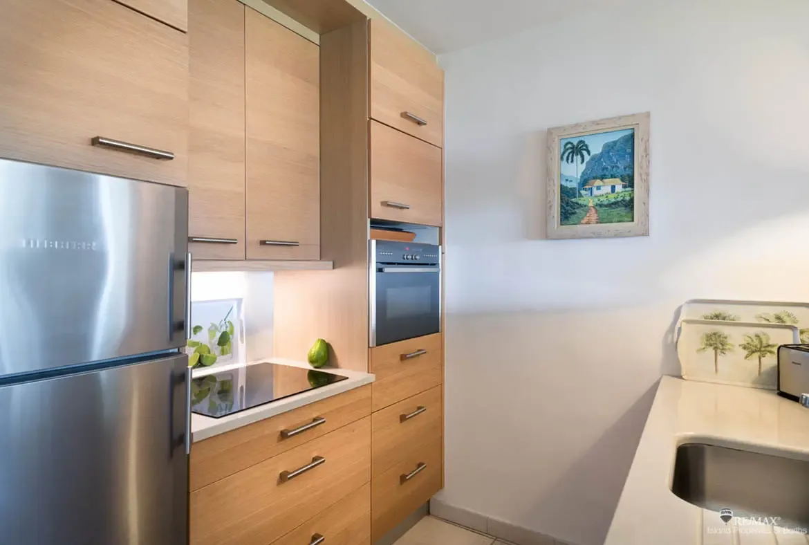 A modern kitchen with stainless steel appliances and light wood cabinetry — prepare meals with island flair.