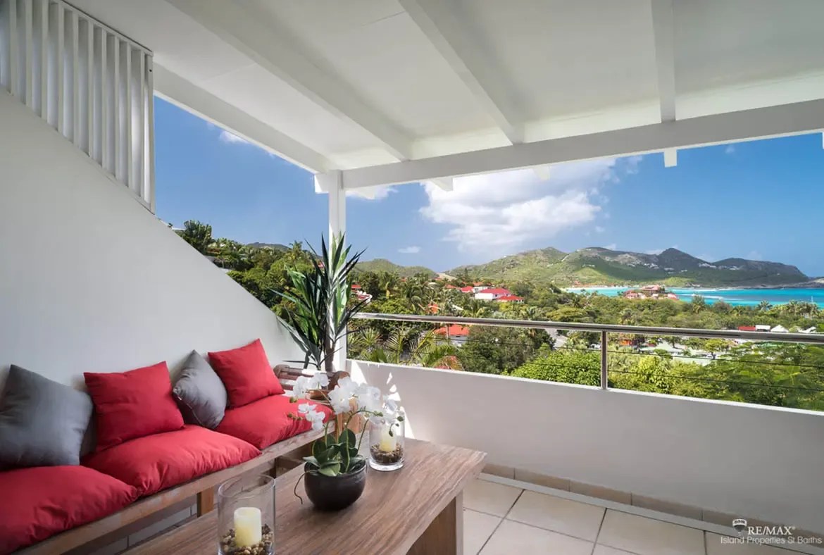 A covered terrace with views of the bay and white sand beach — relax with tropical breezes and island vistas.