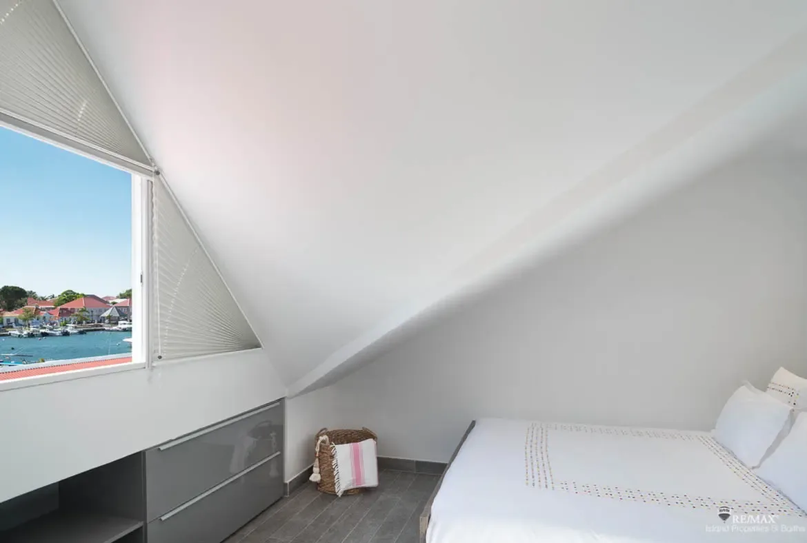 A bright bedroom with harbor views offers a peaceful retreat above the charm of Gustavia.