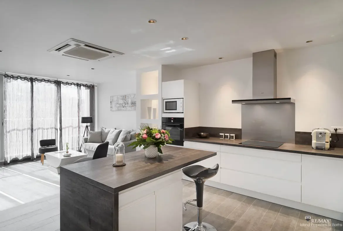 A sleek open-plan kitchen and living space brings modern comfort and effortless island style together.