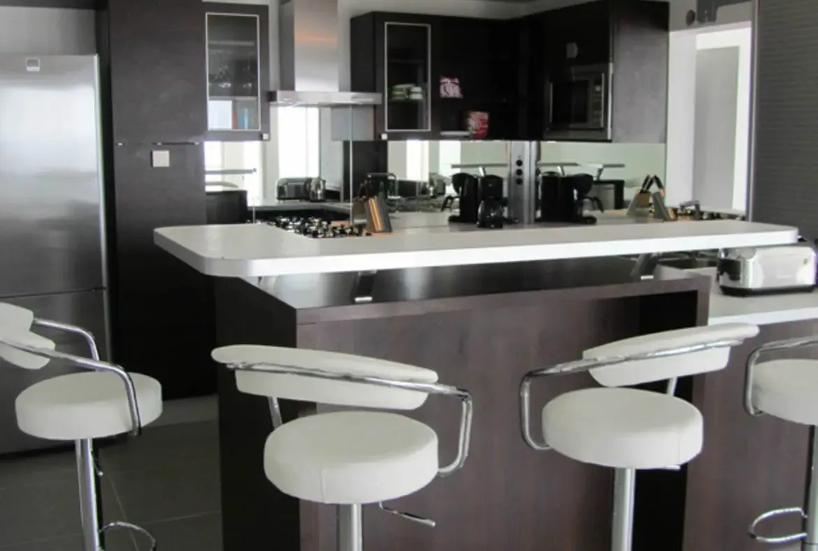 Gather around the sleek kitchen island of Villa Agave Azul, where modern design meets effortless entertaining. Craft cocktails or savor morning coffee at the plush bar stools, with premium appliances and open sightlines creating a seamless social space in St. Barts.                                                                                                                                                                                                                                     +
 
