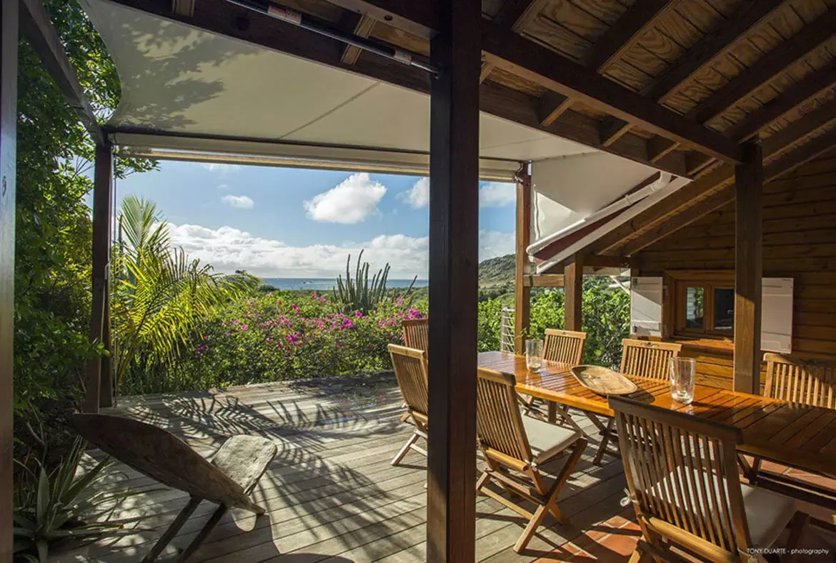 Savor meals under a wooden canopy with panoramic ocean vistas, where the gentle breeze carries the scent of tropical blooms. This private terrace blends rustic charm with seamless indoor-outdoor living, perfect for unforgettable moments with loved ones.