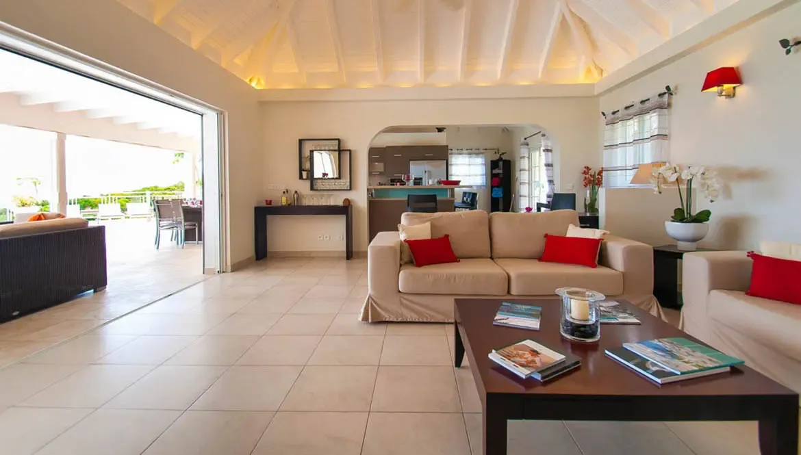 Unwind in this expansive living space where seamless indoor-outdoor flow meets plush comfort. The airy vaulted ceiling and vibrant red accents create a welcoming retreat, while sliding doors open to your private terrace overlooking tropical views.                                                                                                                                                                                                                                                   +
 