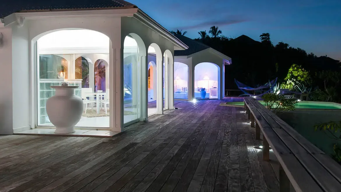 Step onto the spacious wooden deck of Villa Byzance as dusk paints the sky, where illuminated arches reveal cozy interiors and the soft glow of the private pool invites evening relaxation. Let the tranquil St. Barths night wrap around you in this seamless blend of indoor-outdoor luxury.                                                                                                                                                                                                                             +
 