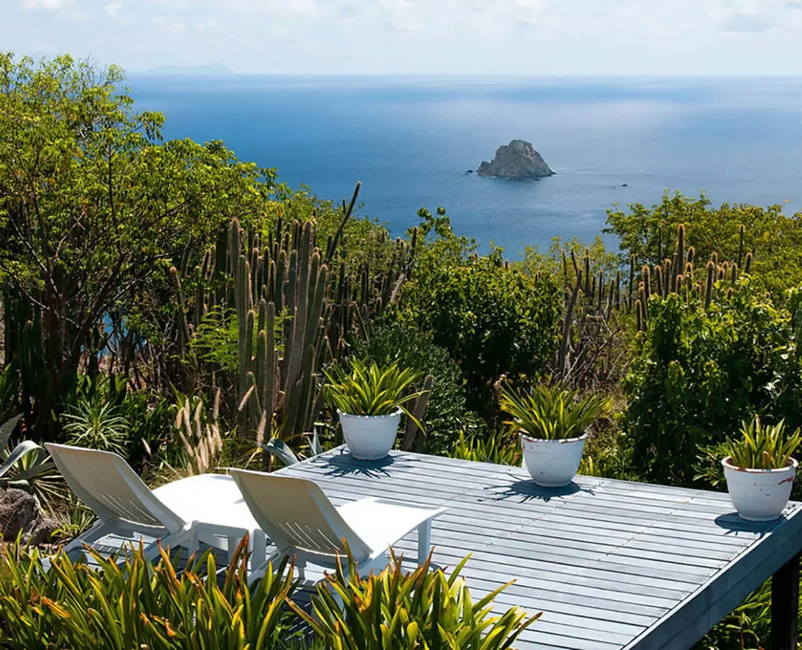 Unwind on the private deck of Villa Byzance, where lush tropical greenery frames uninterrupted ocean vistas and a distant island. Sink into white lounge chairs as the Caribbean breeze carries the rhythm of the sea, crafting moments of pure tranquility.                                                                                                                                                                                                                                                                  +
 