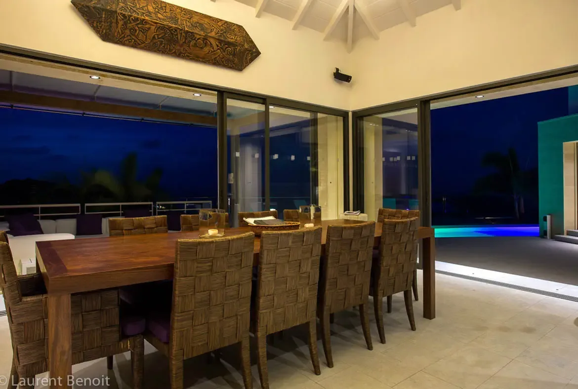 Gather around the hand-crafted timber table as twilight deepens into velvet night. Massive glass doors disappear to merge your dining experience with the glowing pool deck, creating an intimate setting for lingering dinners.