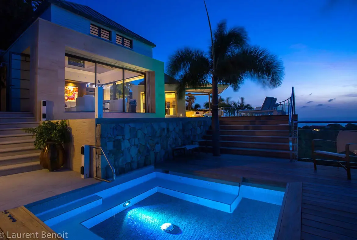 Perched high above the coastline, this split-level terrace captures the essence of a serene Caribbean twilight. The "edge of the world" views stretch across lush hills to the deep indigo horizon.