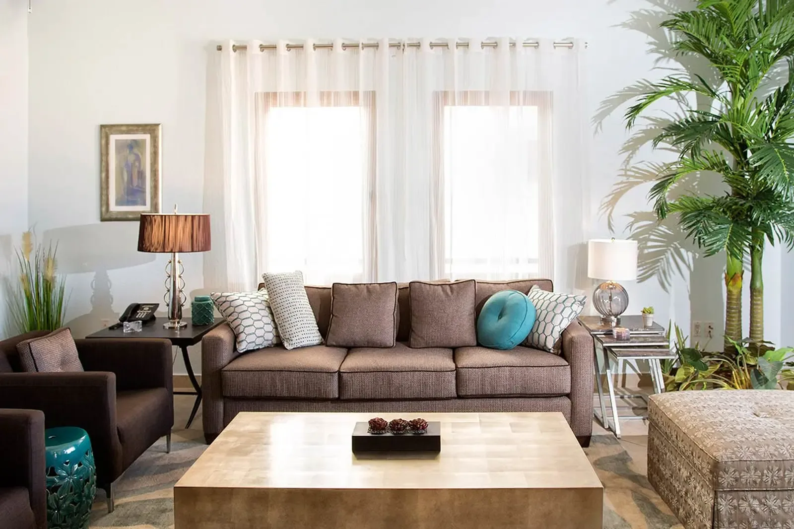 A curated sanctuary of warm wood, cool chrome, and organic textures — where a sculptural gold-leaf coffee table anchors a room bathed in natural light.