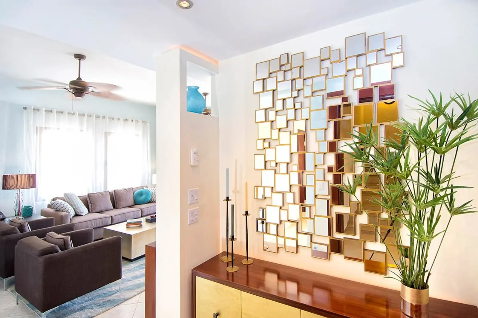 An interlocking geometric mirror installation transforms the entryway into a luminous gallery, bouncing light through a home of quiet sophistication.