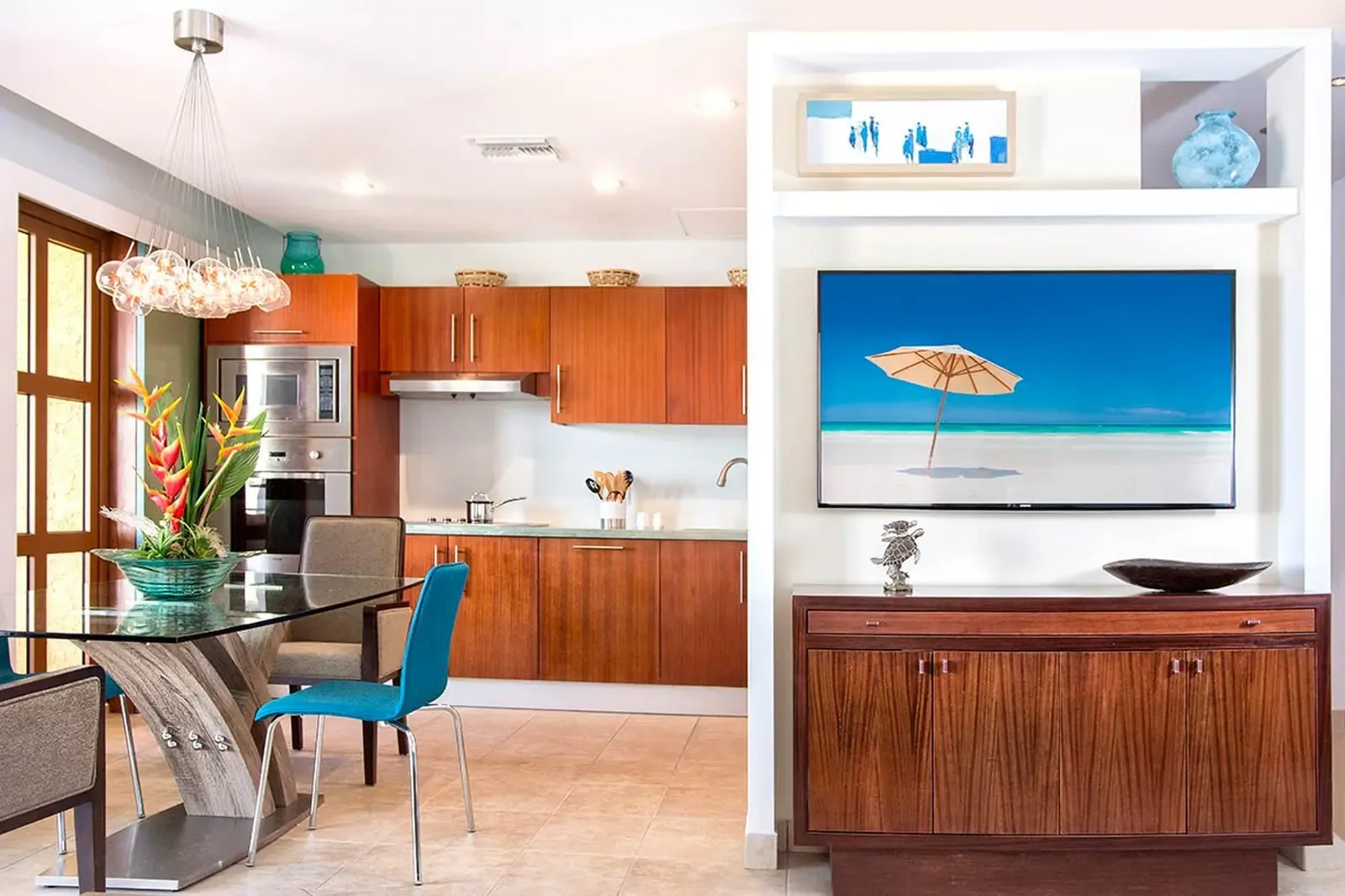 Expansive glass doors dissolve the line between inside and out, filling a serene interior with the colors of sky, sea, and manicured gardens.