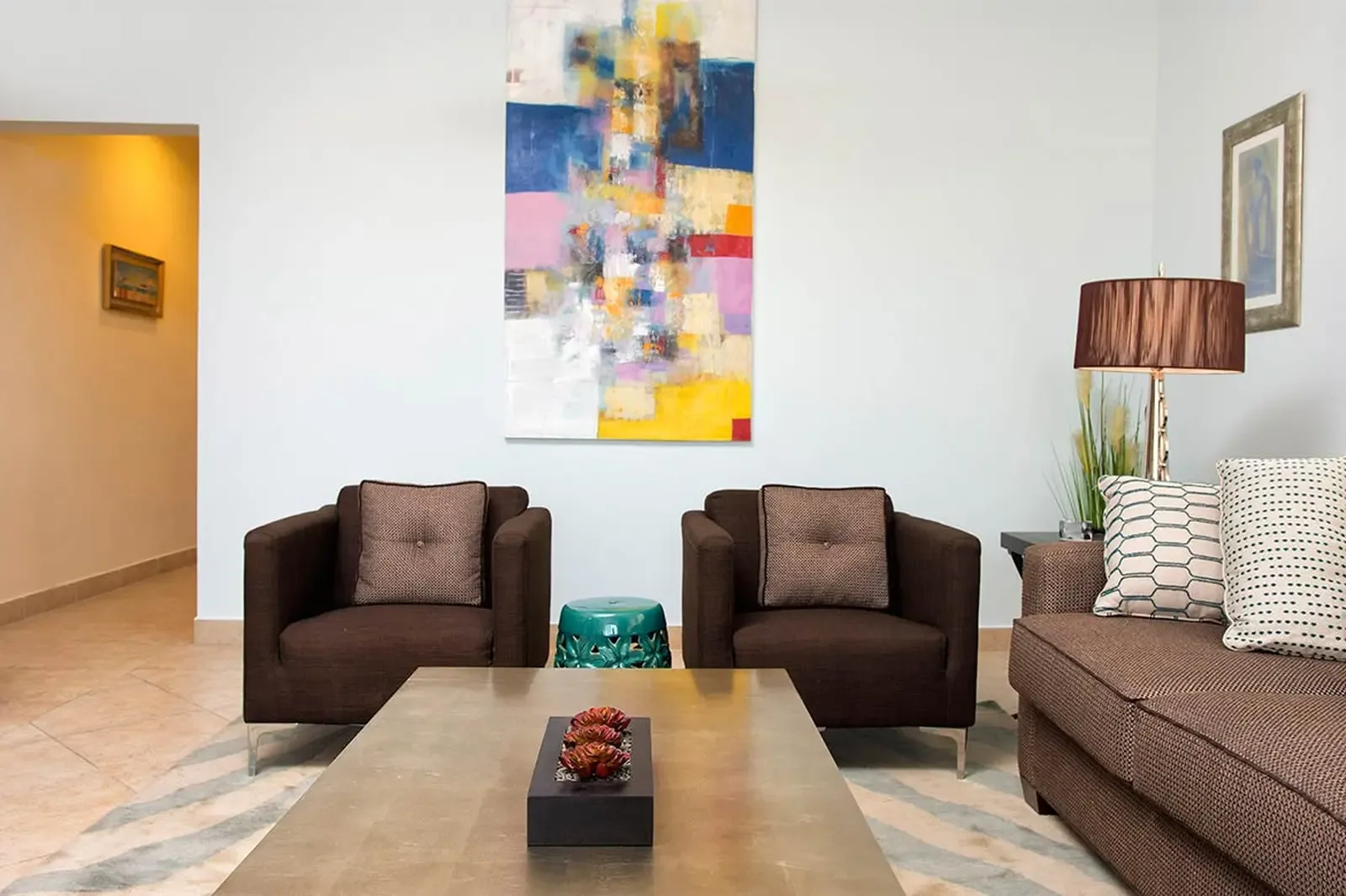 Bold contemporary art meets refined comfort in an open-concept living space, where a gallery-scale canvas sets the tone for stylish island living.