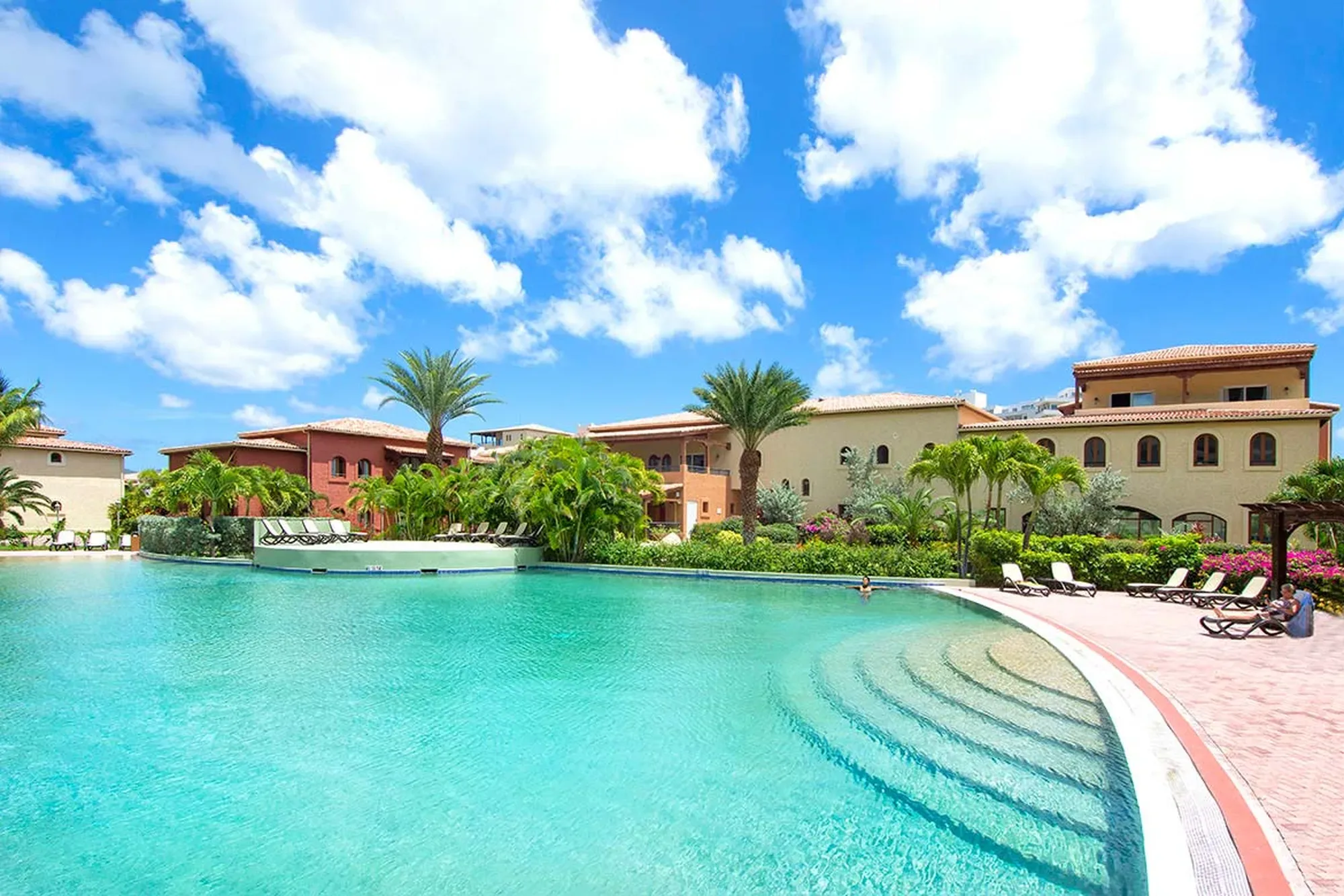 An infinity-edge pool mirrors the endless horizon, where the deep blue of the Caribbean Sea meets the villa's private tropical sanctuary.