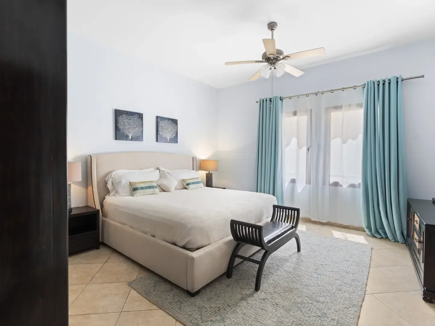 Spa bathroom with a white oval freestanding soaking tub, matte black fixtures, and vertical tile wainscoting in a serene setting.