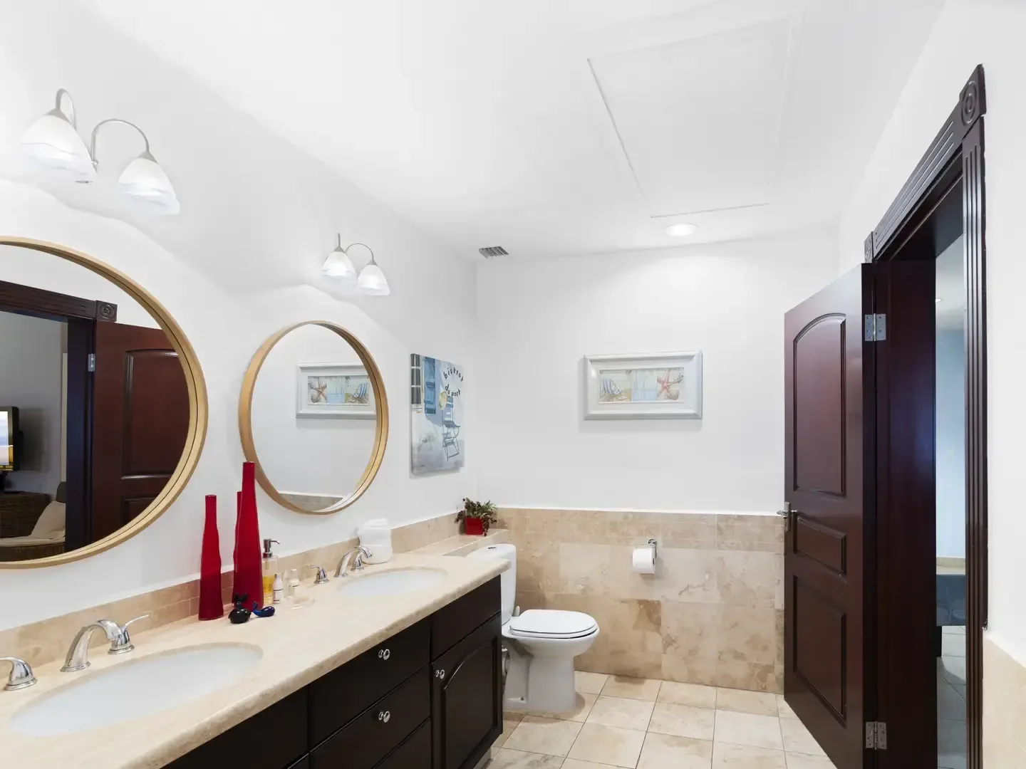 Modern bathroom walk-in shower with travertine tile walls, a rain showerhead, and chrome fixtures on a beige stone floor.