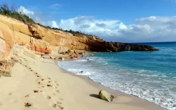 Pristine beach with crystal-clear turquoise waters and dramatic cliffs — your slice of Caribbean paradise.