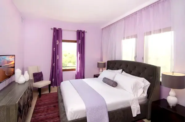 Luxurious master suite with elegant tufted headboard and premium linens — your retreat awaits.