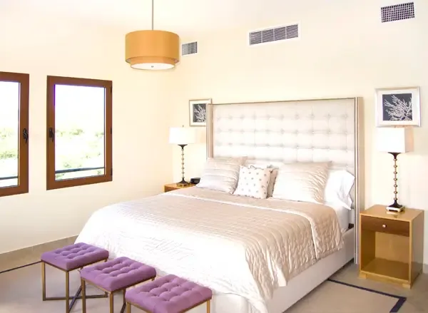 Designer bedroom with vibrant purple accents and curated artwork — a stylish and comfortable escape.