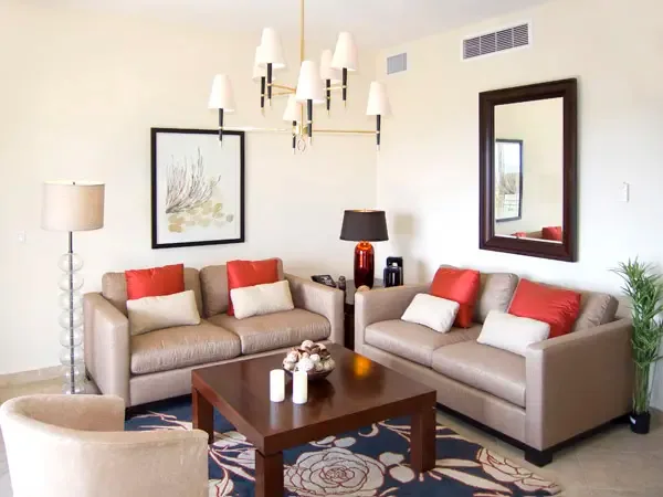 Sophisticated living space with plush seating, vibrant accents, and designer chandelier — an elegant retreat after a day at the beach.