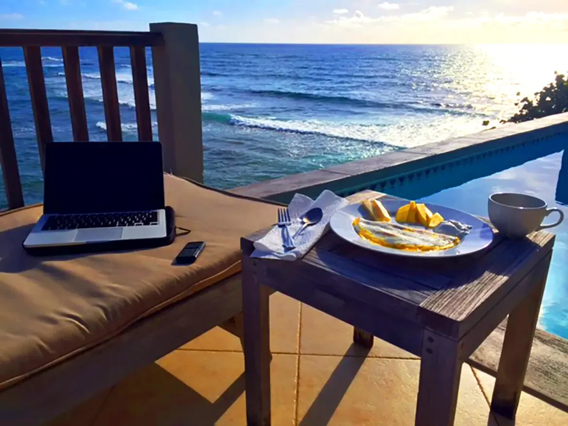 Work from paradise — your private balcony with pool views, ocean breeze, and fresh Caribbean cuisine.