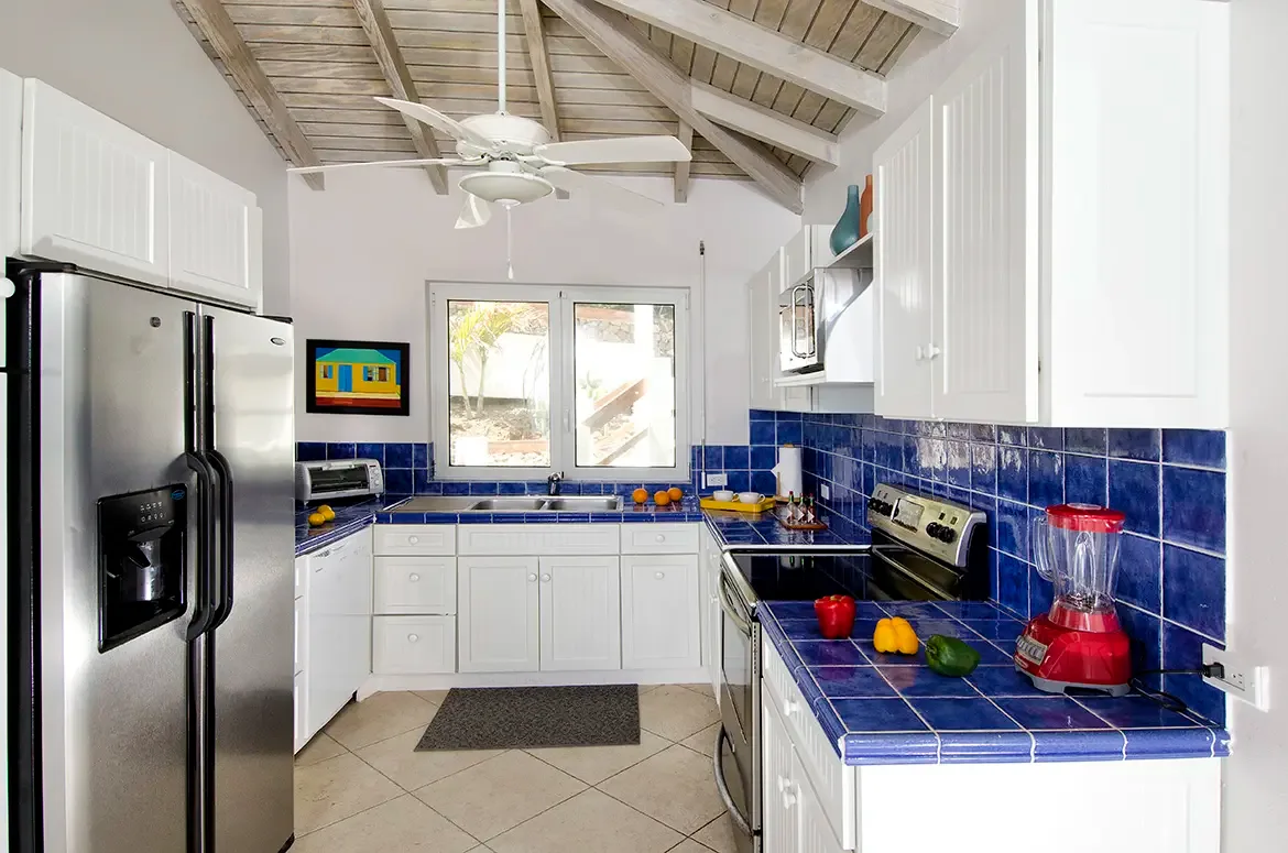 Stylish kitchen with exposed wooden beams, stainless steel appliances, and coastal elegance.