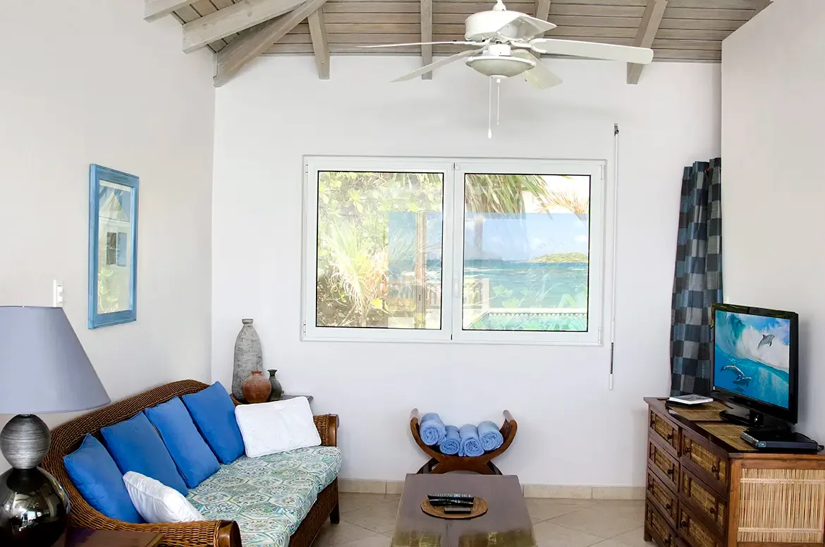 Modern comfort meets island elegance — relax with entertainment while the ocean sparkles beyond.