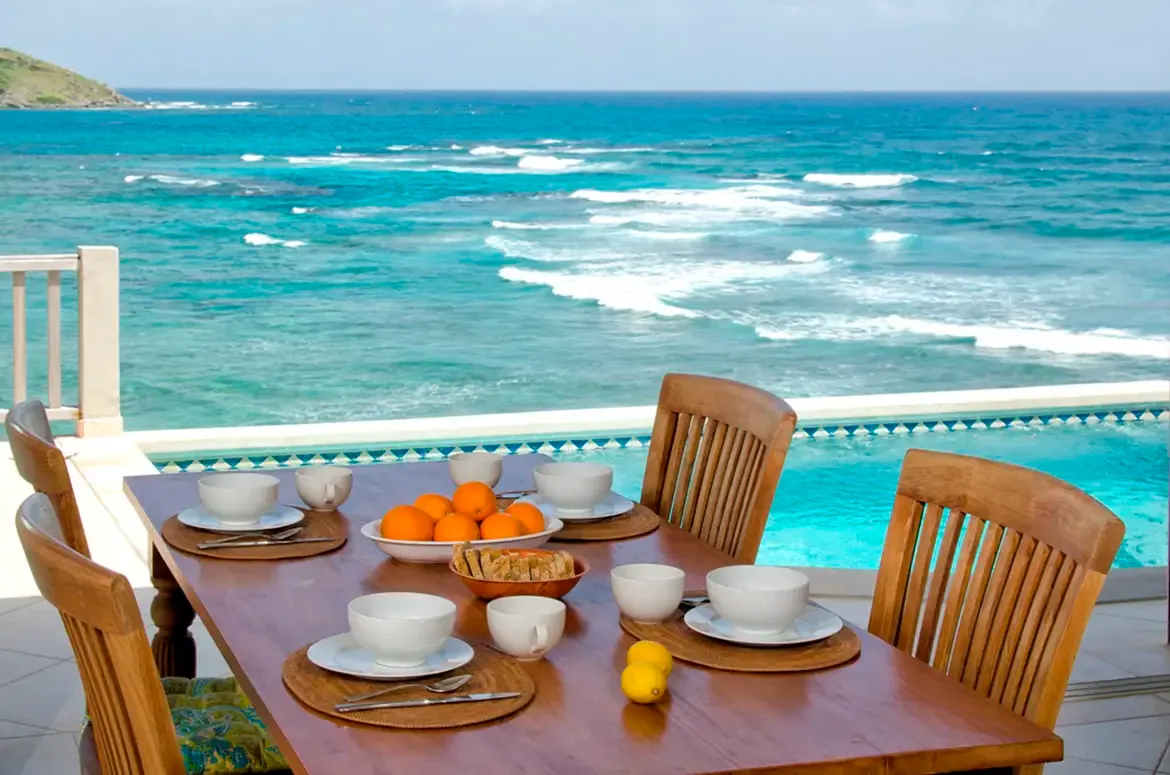 Savor outdoor meals on the terrace with pool views and the turquoise ocean stretching to the horizon.