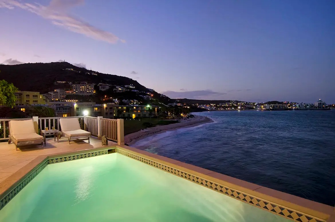 Magical twilight moments by the illuminated pool as city lights sparkle across the bay.