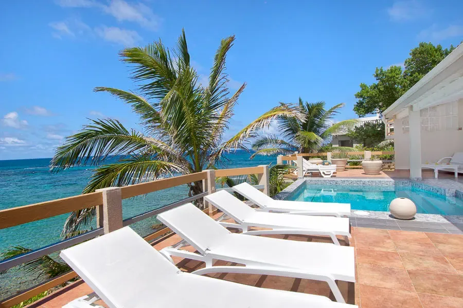 Your private pool deck awaits — lounge in luxury surrounded by palm trees and the sounds of the Caribbean.