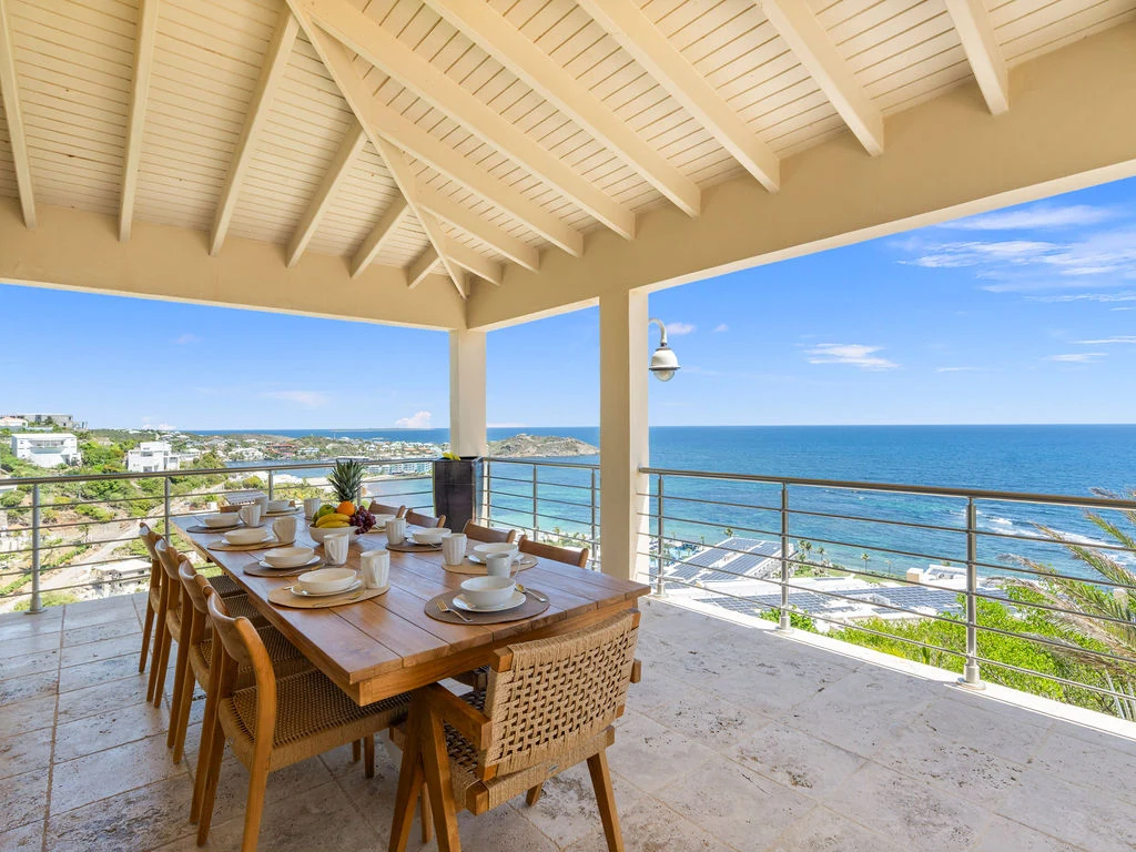 Covered outdoor dining terrace with ocean views