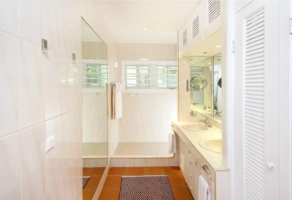 En-suite bathroom with double vanity and walk-in shower — natural light floods through the window.