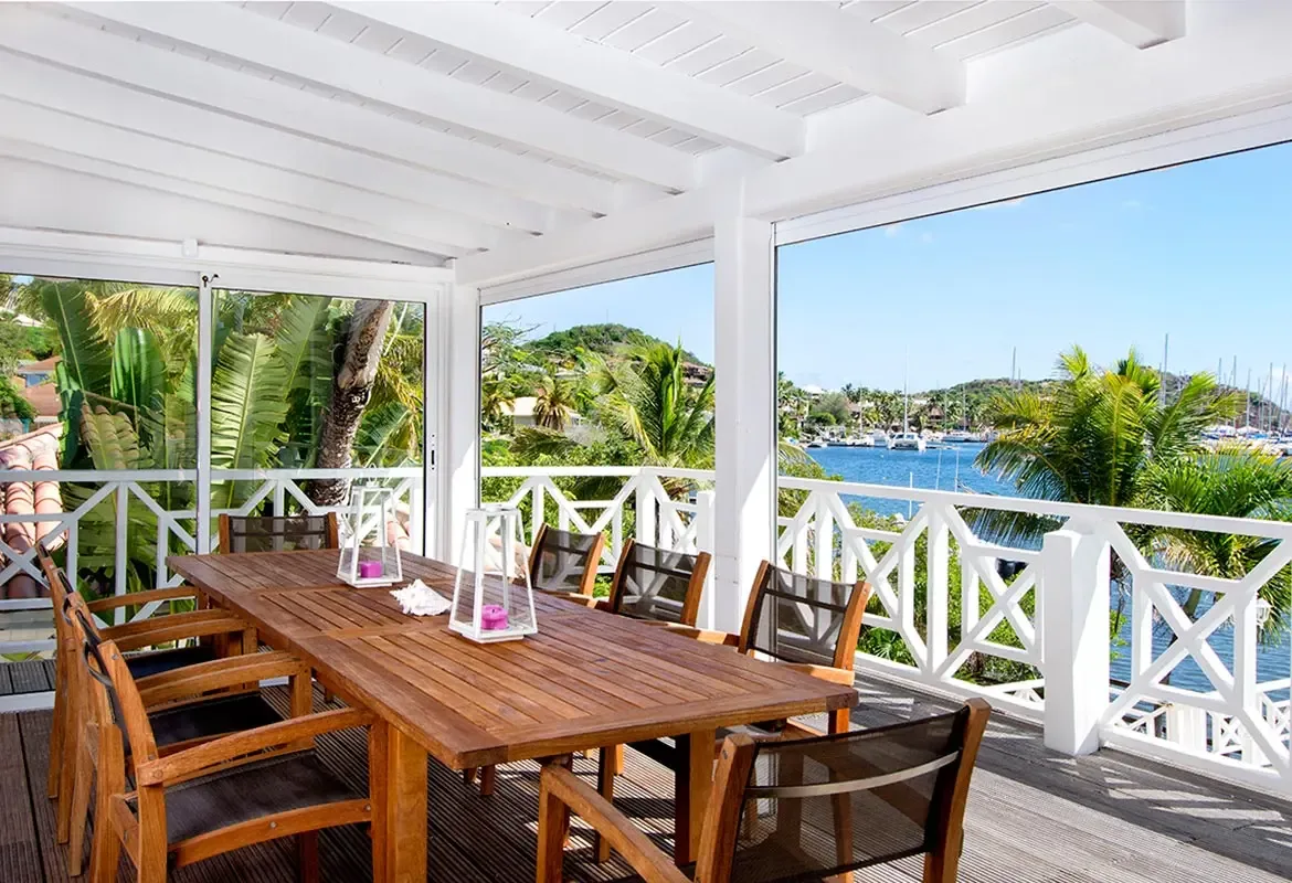 Dine al fresco on the covered terrace — white lanterns and panoramic harbor views create the perfect evening setting.