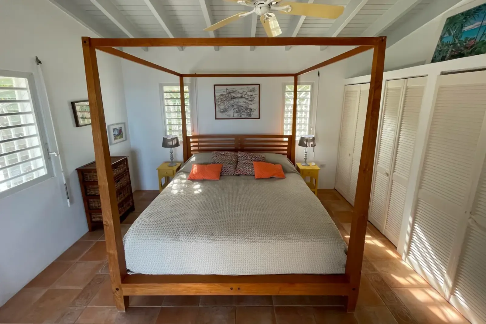 A four-poster bed with wicker wardrobe — Caribbean charm in every detail.