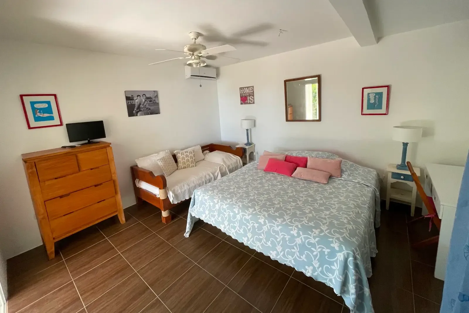 Comfortable bedroom with TV and desk — your private retreat after a day at the beach.