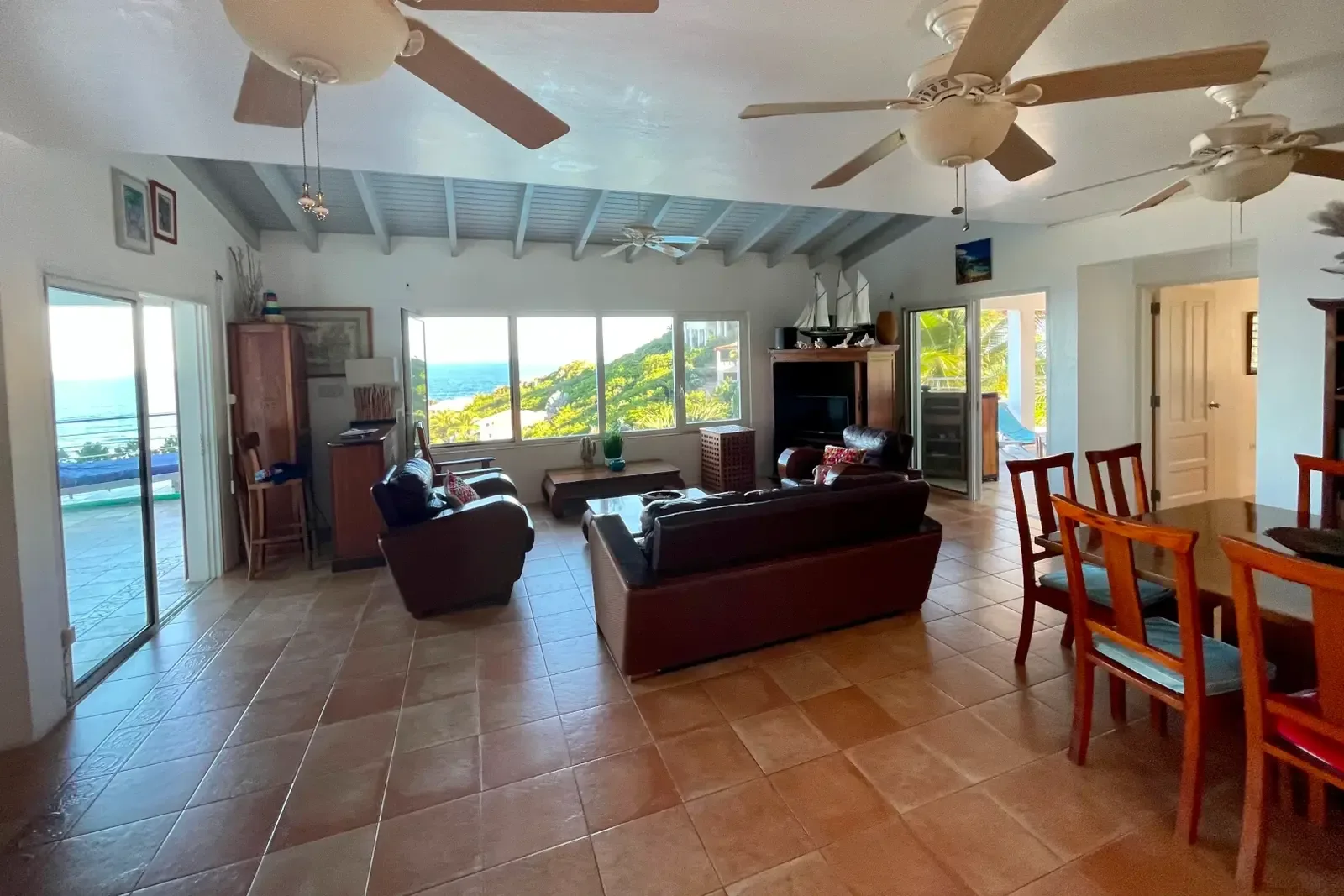 Spacious living and dining under ceiling fans — where every seat has an ocean view.