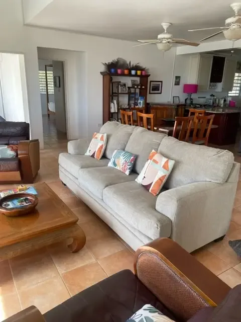 Open-concept living flows to the dining area — gather with friends in this airy tropical space.