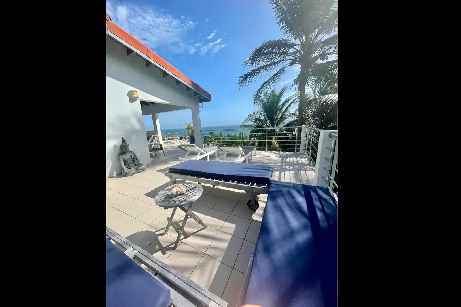 A Buddha statue guards your terrace lounge — serenity meets ocean views.
