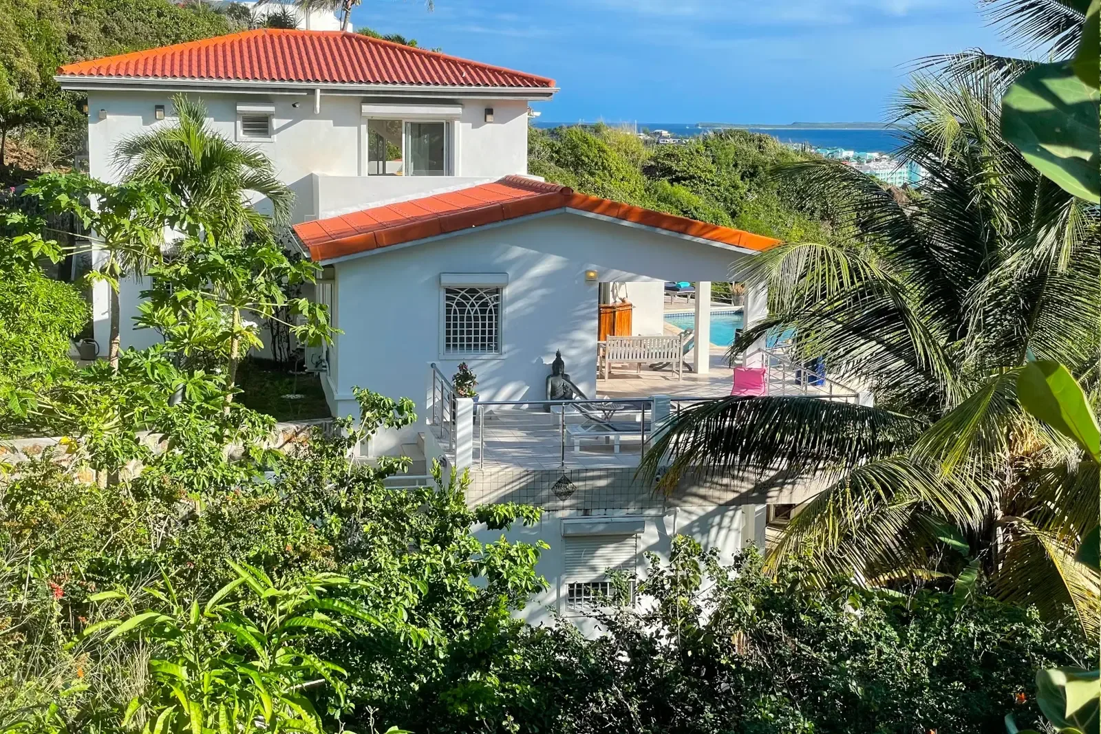 Side view of your tropical retreat — pink bougainvillea and ocean glimpses.
