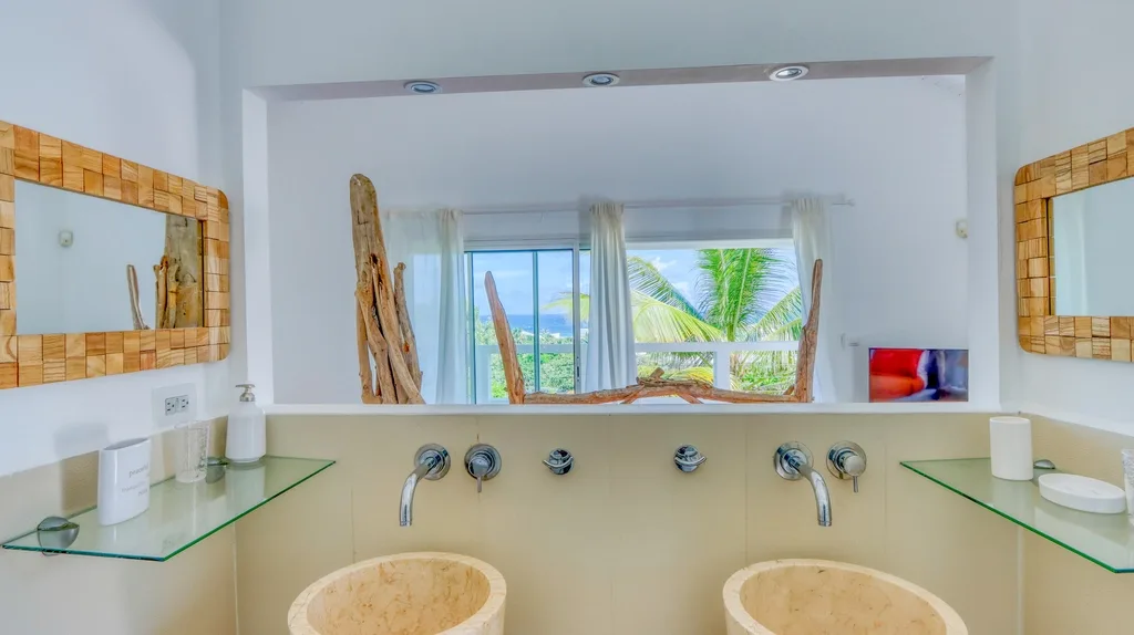 Double vanity bathroom with large mirror and garden-facing window