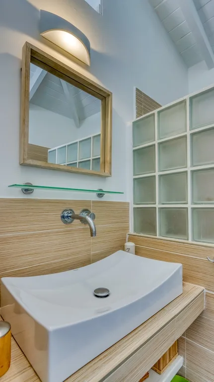 Bathroom sink detail with mirror and glass-block shelving