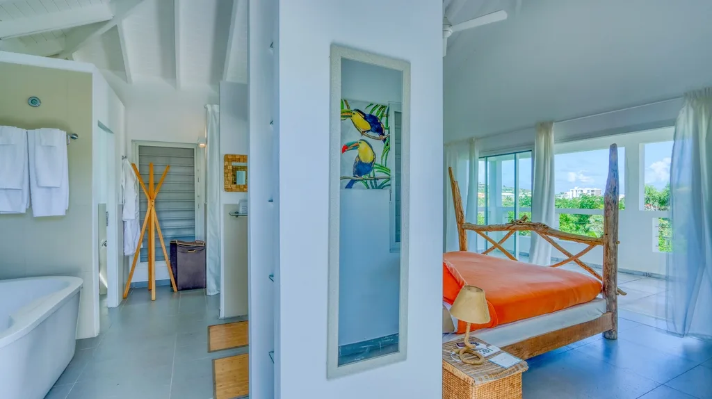 Bathroom with freestanding tub and open view toward the bedroom