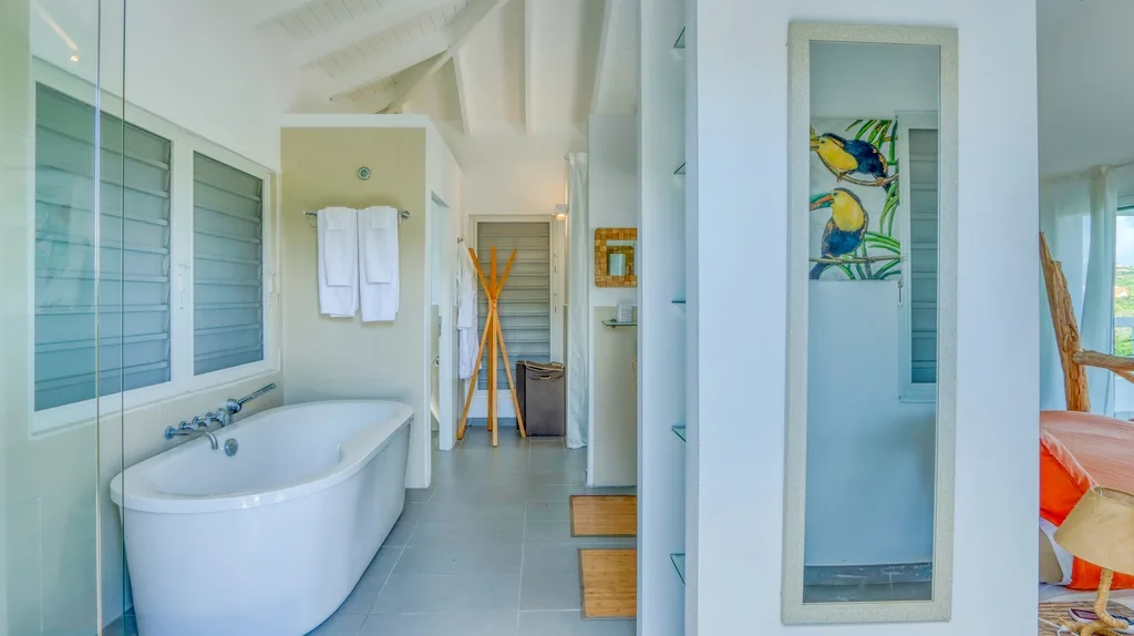 Bathroom with freestanding tub, glass shower, and white tile finishes