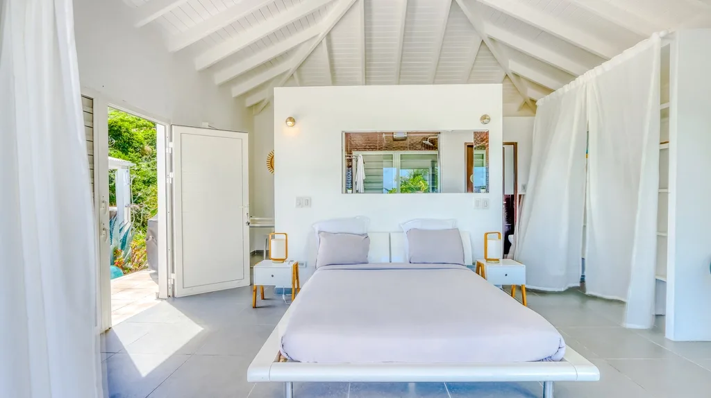 White canopy bedroom with vaulted ceiling and garden outlook