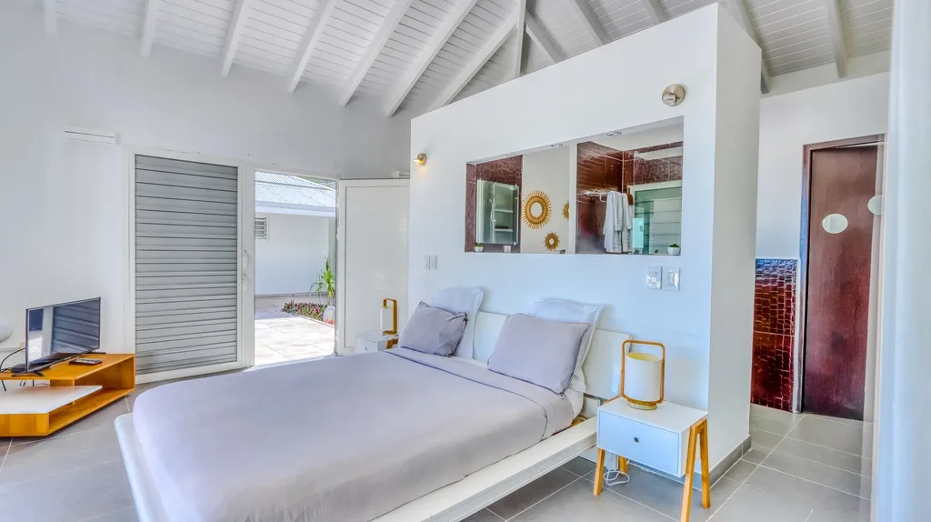 Bedroom with garden view, desk nook, and exposed beam ceiling