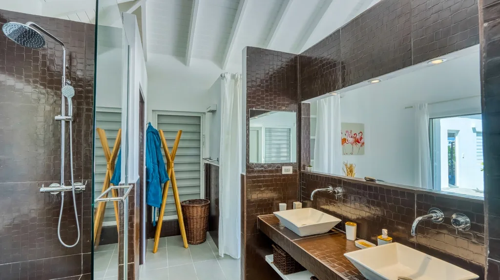 Ensuite bathroom with double vanity, dark tile wall, and walk-in shower