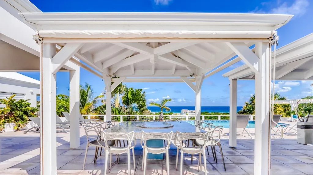 White gazebo dining area beside the pool terrace