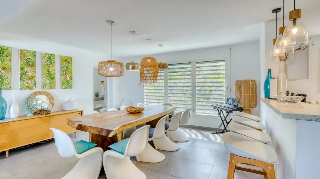 Open-plan dining and living area with wood table and pendant lights