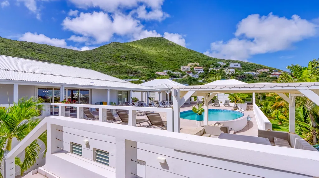 Upper deck and pool view with hillside backdrop