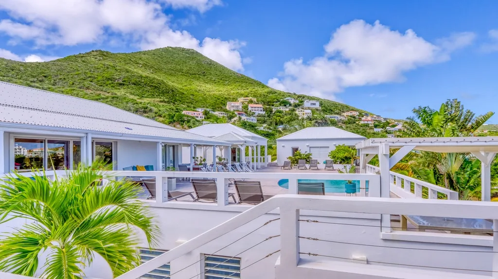 Upper deck view over the villa roofs toward the pool terrace